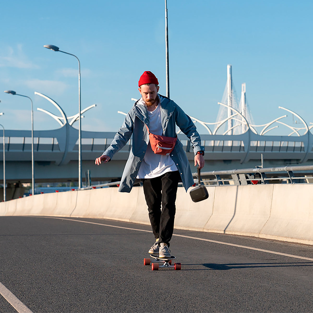 AFA04536 - Rugged Armor® Pro Cable Organizer Bag in black showing a man on a skate board holding the bag by it's strap