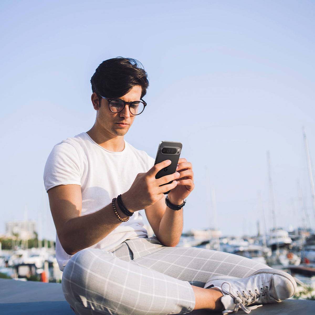 AGL08444 - Pixel 9 Case Optik EZ Fit Lens Protector in Crystal Clear showing a man holding the device with the installed lens protector