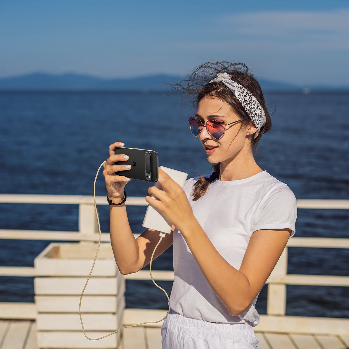 AGL08443 - Pixel 9 Pro Case Optik EZ Fit Lens Protector in Crystal Clear showing a woman holding the device with the installed lens protector